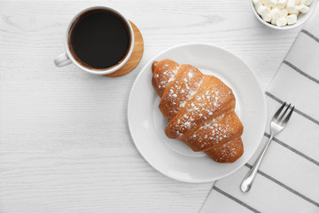Delicious morning coffee and croissant on white wooden table, flat lay