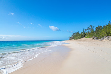 Looking along the idyllic Elbow Beach on the island of Bermuda, with a blue sky overhead