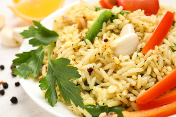 Tasty rice pilaf with vegetables on white table, closeup