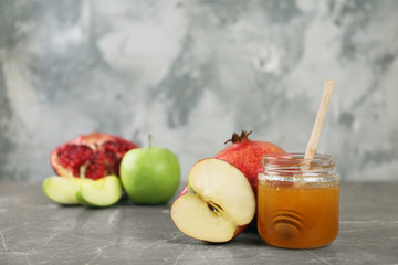 Honey, apples and pomegranate on marble table. Rosh Hashanah holiday