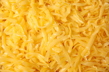 Delicious grated cheese as background, top view
