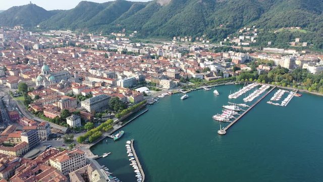 Picturesque view of city of Como on shore of Lake Como on background of mountain at sunny morning, Italy