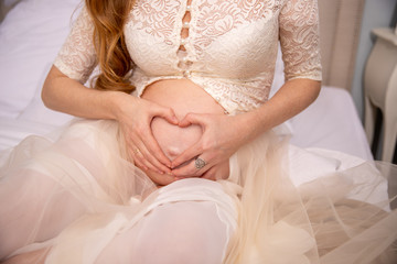 Obraz na płótnie Canvas Pregnant girl close-up belly. Heart on her stomach