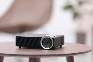 Modern video projector on wooden table indoors - obrazy, fototapety, plakaty