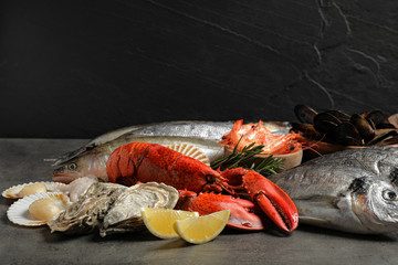 Fresh fish and different seafood on grey table