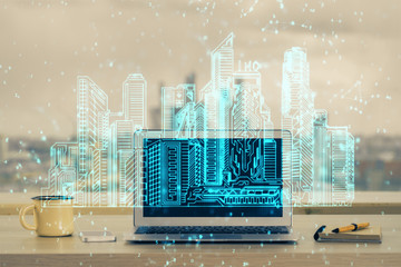 Desktop computer background in office and big town buildings hologram drawing. Double exposure. Smart city concept.