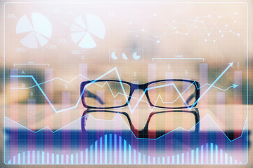 Financial graph hologram with glasses on the table background. Concept of business. Double exposure.