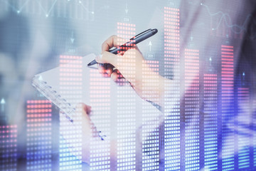 Multi exposure of hands making notes with forex chart huds. Stock market concept.