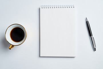 white office Desk top view with Notepad, pen and coffee Cup, minimalistic design, top view,copy space,flat lay