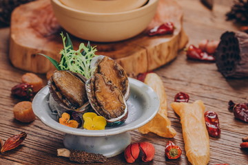 Three abalone, cooked in stock, garnished with vanilla.