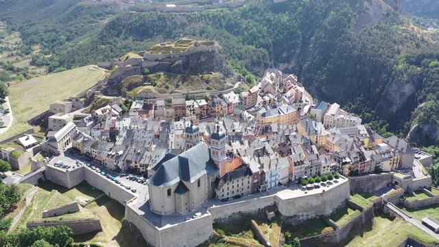 Picturesque autumn landscape with imposing medieval citadel on hilltop on background with French fortified township of Briancon