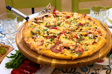 Delicious cheese supreme pizza on wooden board