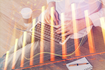 Forex graph with businessman working on computer in office on background. Concept of analysis. Double exposure.