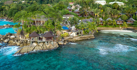 Fototapeta na wymiar Waterfront view at tropical resort with bungalows during evening 