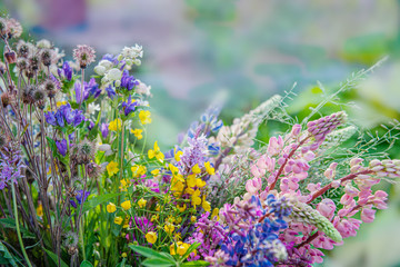 A large bouquet of different wild flowers of blue delphinium, cornflower, Buttercup on a Sunny summer day.