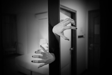 Horror shoot, hand of woman out from the closet in white tone