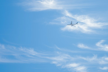 An air plane flying on cloudy blue sky background
