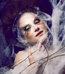 beauty woman with creative make up like cocoon in web, halloween celebrationlook
