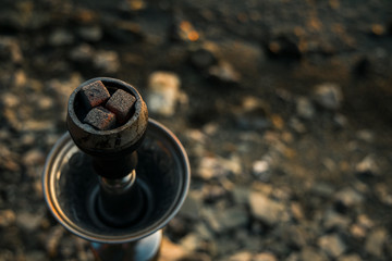 hookah object for relaxation spending time with coals on a plate blurred unfocused background, copy space for text here