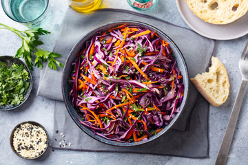 Red cabbage salad, Coleslaw in a bowl. Grey background. Top view.
