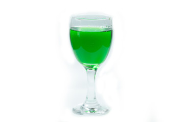 Pouring green water into a drinking glass on white background. No People.