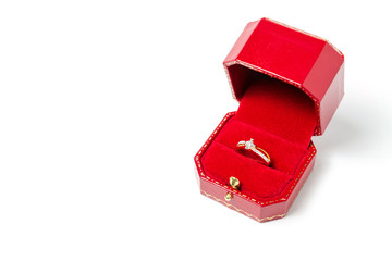 White diamond wedding ring in red gift box isolated on white background.Wedding day gift.