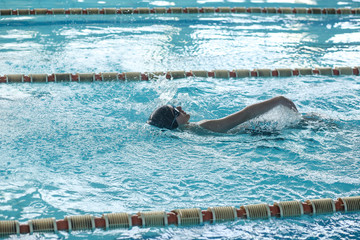 A teenager is swimming in a sports pool