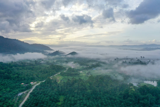 Aerial view misty and foggy morning at the Imbak Village in Tongod, Sabah, Malaysia, Borneo. Certain part with rainforest jungle and palm oil plantation.