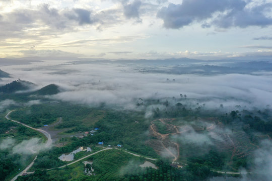 Aerial view misty and foggy morning at the Imbak Village in Tongod, Sabah, Malaysia, Borneo. Certain part with rainforest jungle and palm oil plantation.