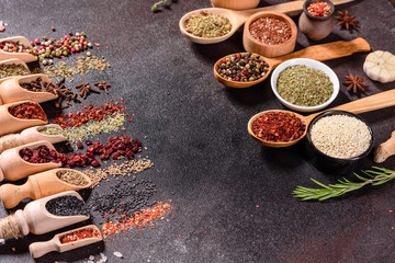 Spices and herbs over black stone background. Top view with free space for menu or recipes