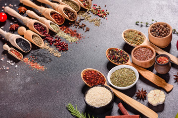 Spices and herbs over black stone background. Top view with free space for menu or recipes