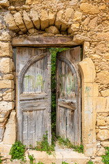 Fototapeta na wymiar Old and ruinous door in a old greek village during daytime