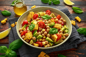 Avocado chickpea salad with grilled sweet corn, tomato and basil. Healthy vegan food