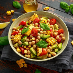 Avocado chickpea salad with grilled sweet corn, tomato and basil. Healthy vegan food