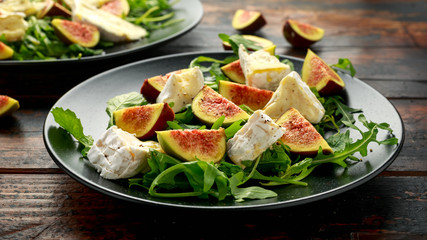 Vegetarian camembert cheese, fig and Arugula, hot rocket salad served on black plate