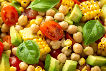 Avocado chickpea salad with grilled sweet corn, tomato and basil. Healthy vegan food