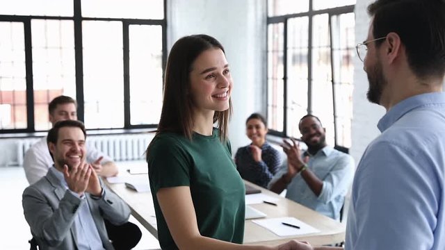 Happy young businesswoman intern get rewarded promoted handshake manager