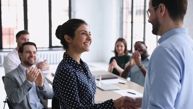 Confident proud indian employee of month handshaking company boss