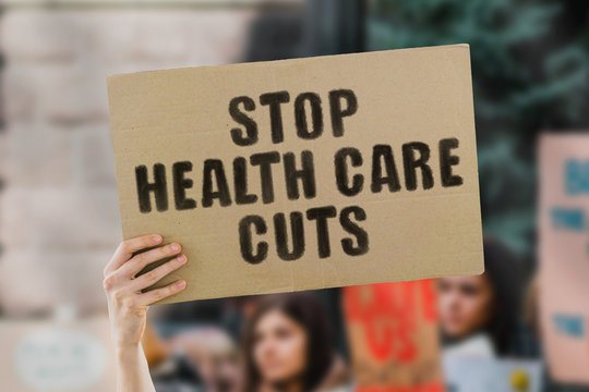 The phrase " Stop health care cuts " on a banner in men's hand. Human holds a cardboard with an inscription. Healthy. Life. Medical. Human. Government. Power. Changes. Power. 911. Help. Rescue