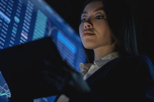 The business woman holding tablet in the dark office