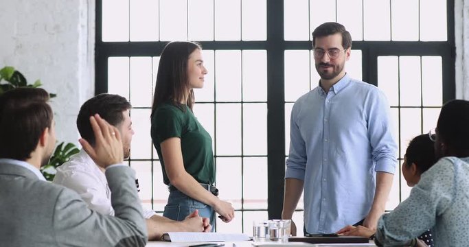 Happy female intern trainee get appreciated handshake boss in office