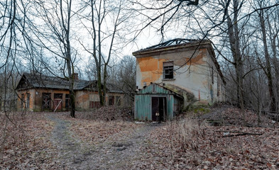 Dilapidated abandoned buildings in a city forest park