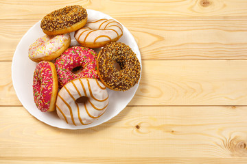Glazed donuts in a plate on the background Board