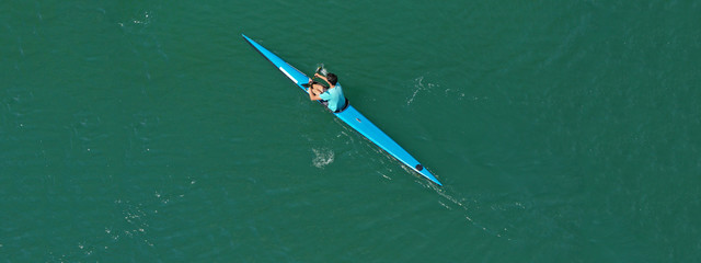 Fototapeta na wymiar Aerial drone ultra wide photo of fit athletes practising sport kayak in tropical exotic lake with emerald water