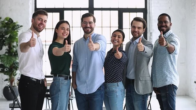 Happy professional diverse businesspeople show thumbs up look at camera