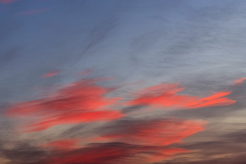Naklejka premium Purple clouds float through the sky before sunrise.