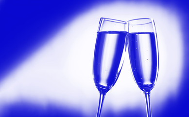 Two festive wine glasses on blank background, place for text.