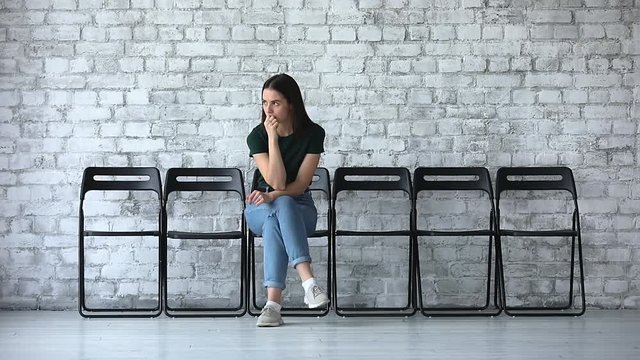 Stressed millennial businesswoman wait for job interview sit on chair