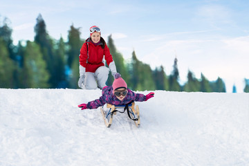 Mother Pushing Her Daughter On Sledge