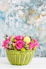 Woman shows how to make Easter table decoration with roses, moss and catkins